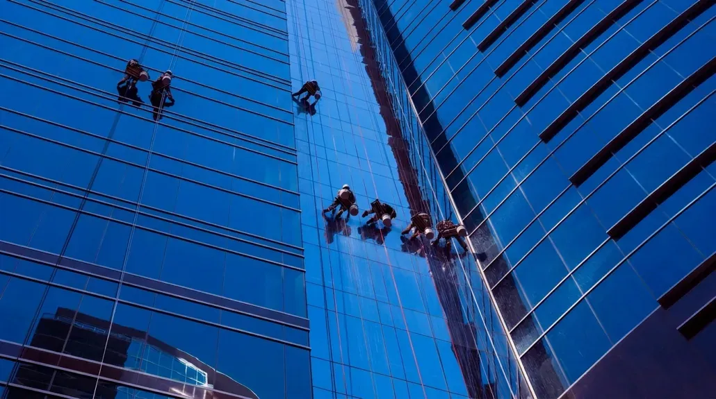 Rope-access window cleaners working on a high-rise glass building